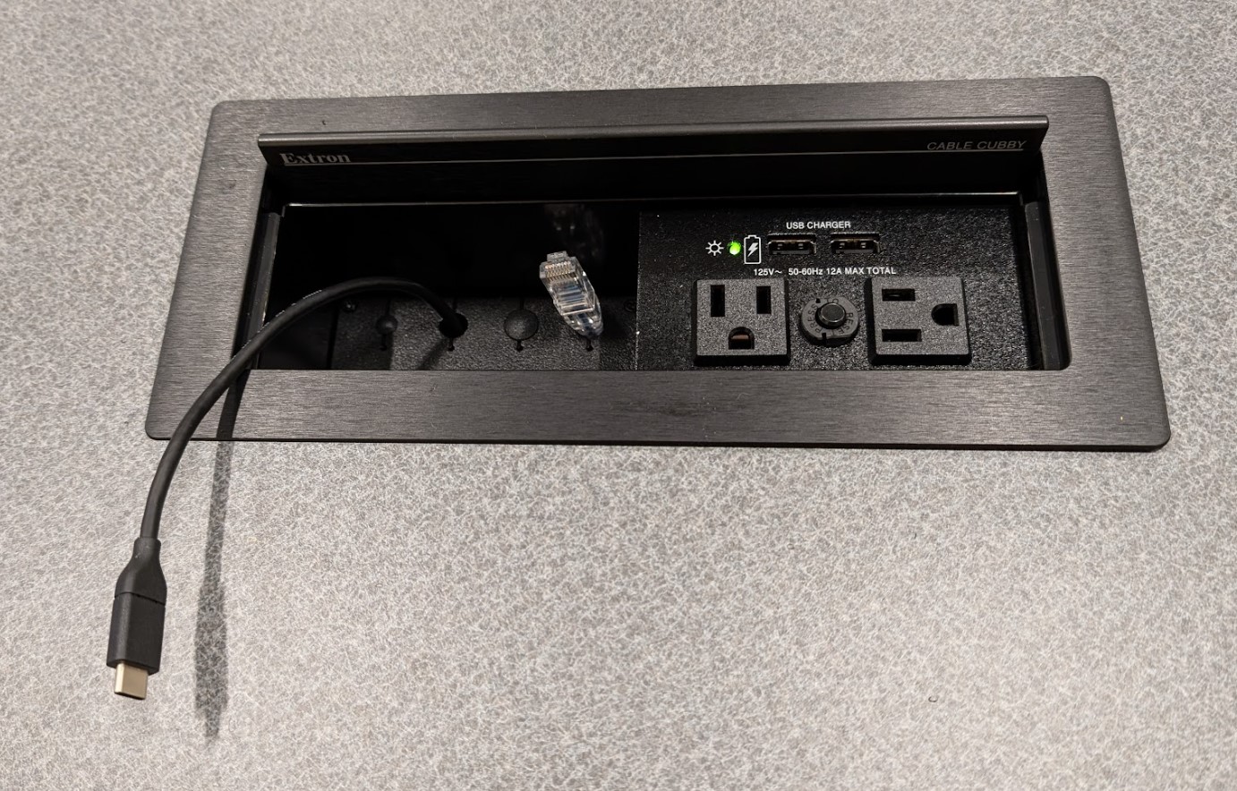 USB-C laptop cable coming out of the instructor desk cable cubby